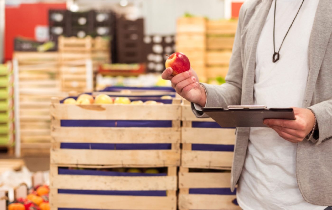 A quality assurance check being carried out on crated fruit in a produce warehouse